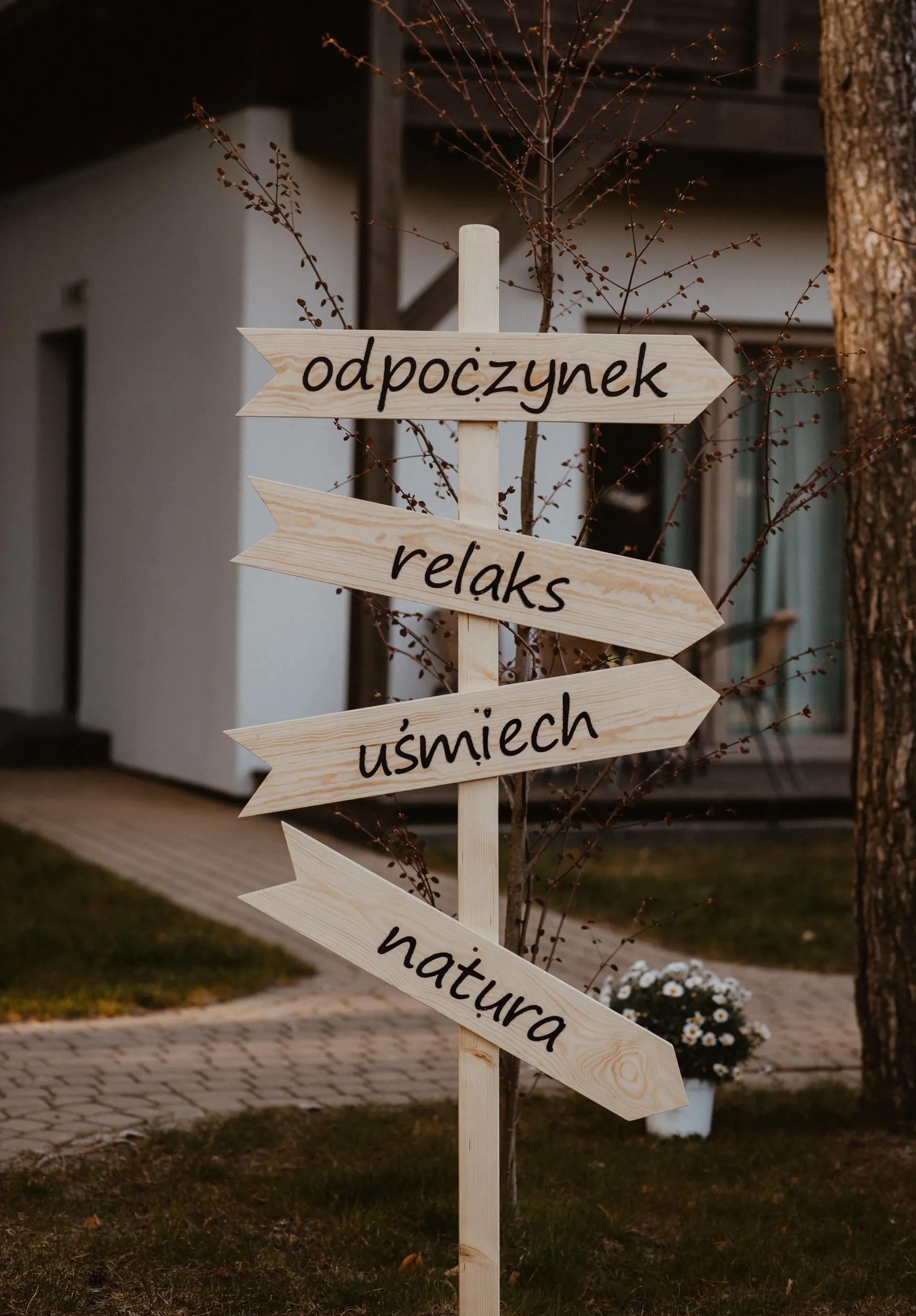 Drogowskaz z hasłami: odpoczynek, relaks, uśmiech, natura — filozofia Poezja Ciszy Dębki